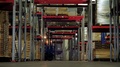 The Driver On The Loader Moves Through The Warehouse Along The Rows