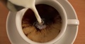 Milk Pouring In Cup With Black Coffee Top View Slow Motion