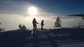 A Skier And Snowboarder Drop In Above The Fog