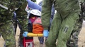 Military Medics Carry Casualty Wrapped In Foil Blanket On Stretcher