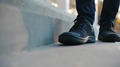 Boy In Boots Walking On The Concrete Stairs And Stops Near The Camera In Focus
