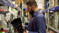 Brutal Man With A Beard In A Hardware Store Chooses Tools.