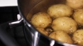Close View Of Potatoes Boiling In A Metal Pot On A Stove. Black Pot Handle