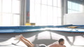 Athlete Is Pretending A Plane While Jumping On The Trampoline