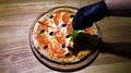 Top View Decorating Fresh Baked Pizza With Basil Leaves In Slow Motion