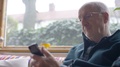 Senior Man Using A Phone At Home