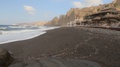 Tracking Shot Of A Black Sand Beach With A Beach Resort In The Foreground