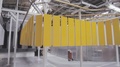 Electrostatic Painting. Yellow Metal Panels Move On An Overhead Conveyor.