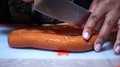 Slicing Long Sausage Into Four Equal Segments, Close Up