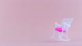 Plastic Rocking Chair Swinging On A Pink Background