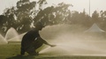 Man Operating Sprinkler On Sports Field To Spray Water