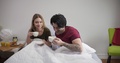 Happy Caucasian Couple Drinking Coffee In Bed, Talking