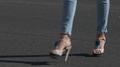 Ungraded: Young Attractive Woman In High Heels And Jeans Walks Along Asphalt