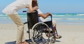 Side View Of Active Senior African American Woman Embracing Disabled Senior Man