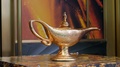 Back View Of The Antique Gold Genie Lamp Of Disney Aladdin On A Pedestal