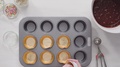 Placing Paper Cupcake Liners Into Cupcake Pan To Bake Unicorn Chocolate Cupcakes