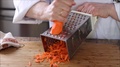 Chef In Kitchen Shredding A Carrot.
