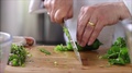 Chef In Kitchen Slicing And Mincing A Jalapeno.