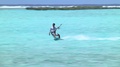 Adult Male Kite Surfing Across Ocean And Slowly Coming To A Stop In French