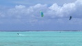 Two People Kite Surfing In Open Waters In French Polynesia. Wide Angle And