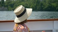 A Woman Traveling With Hat Drinks Bottled Water On Ferry On Lake Como, Italy, Eu