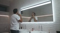 Handsome Man Shaving Beard In Luxury Bath. Concentrated Man Shaving In Bathroom