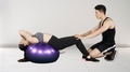 Trainer Helps His Client Exercise On Pilates Ball