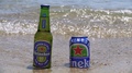Heineken Zero Alcohol Beer Bottle & Can On Sand By The Sea.
