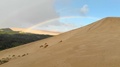 Flying Over A Giant Sand Dune To Reveal A Beautiful Rainbow Arching