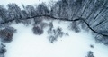 Aerial Drone Shot Flying Up And Above Small River Covered With Snow
