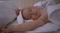A Naked One Year Old Child Sleeps Under A White Blanket In Slow Motion