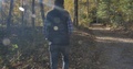 Camera Following A Man Walking Up A Rural Road During The Autumn