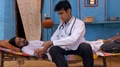 Young Well-Dressed Doctor Observing His Unconscious Patient At The Village Home