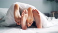 Girls And Guys Feet Caressing In Bed Under Blanket, Couple Enjoying Relationship