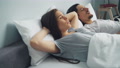 Irritated Woman Covering Head With Pillow When Boyfriend Snoring In Sleep In Bed