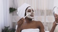 Happy African American Woman In White Towel On Head Applying Yogurt Mask On Face