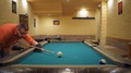 Young Male Is Shooting The Blue Billiard Ball Into A Corner Hole