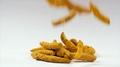 Shot Of Falling Dried Turmeric Roots (Indian Spice) On The Table