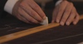 Close Up Footage Of A Tailor Drawing Lines On Fabric And Makes Some Alterations