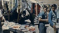 Tossa De Mar, Spain - 1962: People Walk In A Market