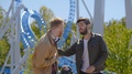 Two Male Friends Exchange Opinions About Their Scary Ride On A Roller Coaster
