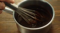 Human Hand Stirring Thick Chocolate With Whisk In Metal Pan. Mixing Filling