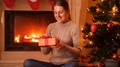 4k Video Of Young Woman Sitting On Floor Next To Christmas Tree And Fireplace
