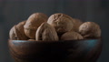 A Bowl Of Walnuts Revolves On A Dark Background. Close-Up.