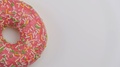 Top View Of Fresh Doughnut With Colorful Sprinkles Rotating At White Background.