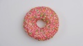 Pink Donut With Colorful Sprinkles Rotating. Colorful Doughnut Spinning