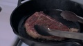Dinner Steak Cooked On A Cast-Iron Skillet Ready To Flip Over With