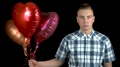 Sad Young Man Let Go Of Heart-Shaped Balloons. A Sad Man Stands With Helium