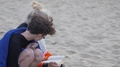Slow Motion Of A Mother Reading A Book And Her Son Crouching Under A