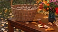 Large Wicker Basket Full Of Walnuts Next To Vase Of Flowers Next To Basket